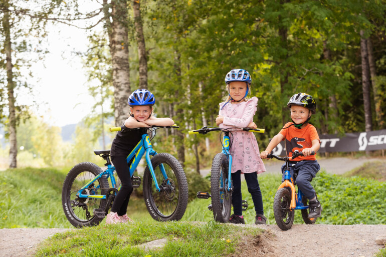 Cykling. Tre små barn poserar med sina cyklar.