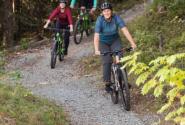 Kompisar cyklar cross country i skog.