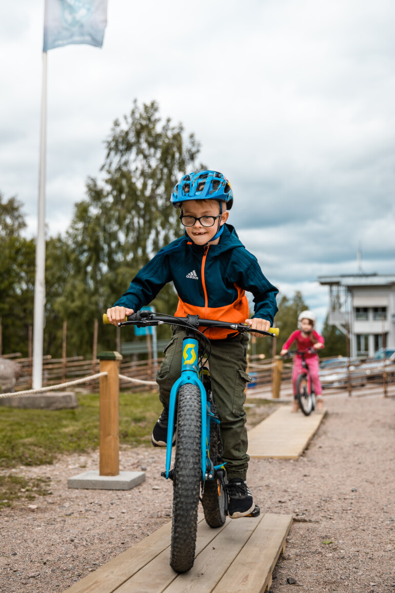 Pojke cyklar MTB med koncentration på träramp.