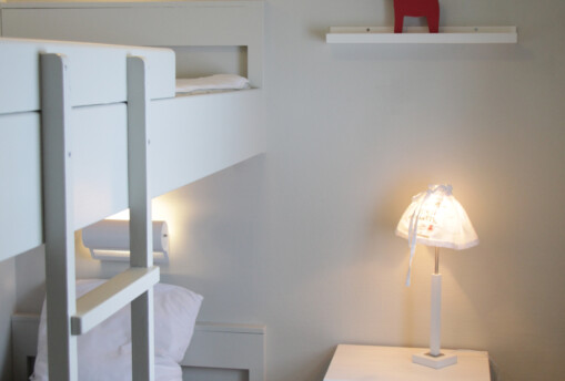 Sovrum i stuga med dalahäst.