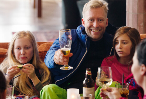 Föräldrar skålar och barnen fikar efter skidåkning.