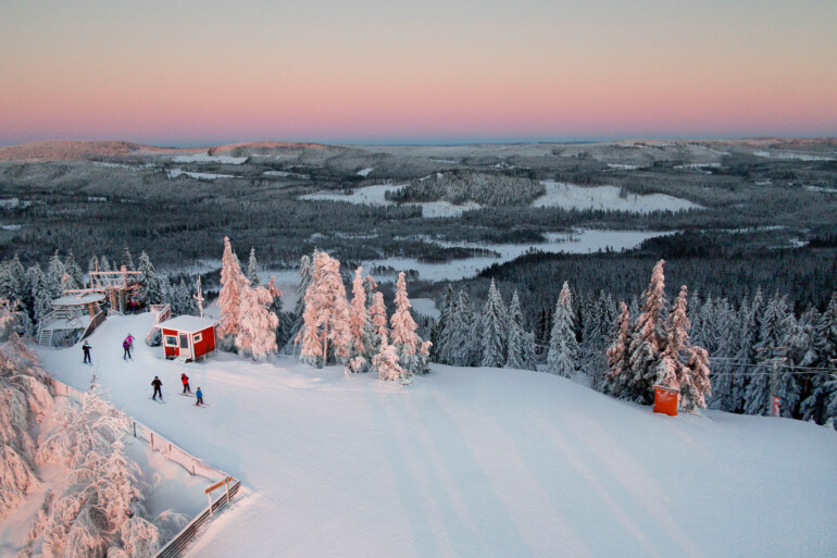 Översiktsbild Säfsen skidbacke med skidåkare i kvällsljus.