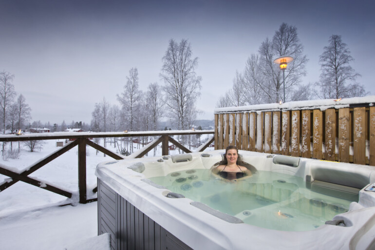 Kvinna i utomhusjacuzzi vinter.
