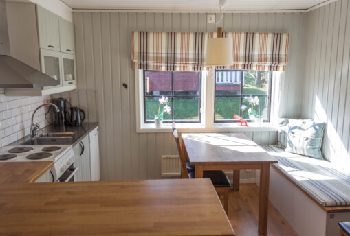 Kök i stuga med furumöbler och träpanel.