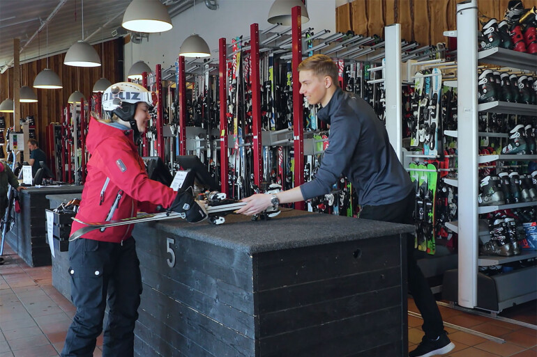 Kvinna hämtar ut skidor i skiduthyrningen.