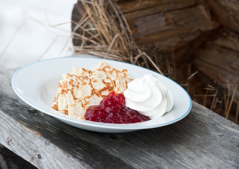 Tallrik med pannkakor, grädde och sylt
