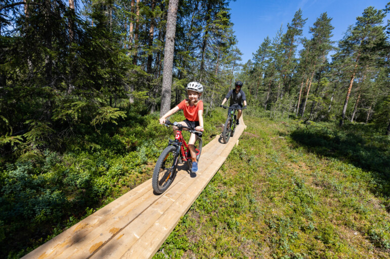 Pappa och dotter cyklar på spång
